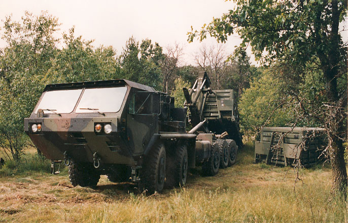 HEMMT truck offloading a PLS flat rack